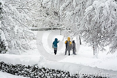 Happy family in winter clothes walking in a snow covered park city, healthy lifestyle. Stock Photo