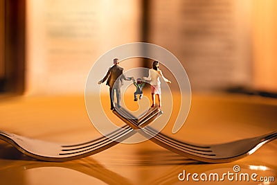 Happy Family and Work Life Balance Concept. Miniature of Father, Mother and Son holding Hands and Walking on the Fork Stock Photo
