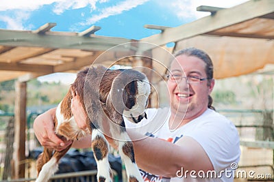 Happy farmer with a goatling Stock Photo