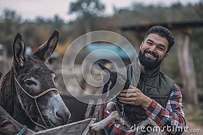 A happy farmer holding a cute goatling Stock Photo