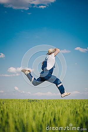 Happy farmer in the wheat against blue sky with white clouds Stock Photo