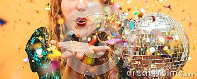 Happy fashion girl blowing confetti holding vintage disco ball - Party concept - Focus on mouth Stock Photo