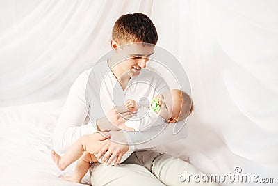 Happy father with baby on bed home bedtime Stock Photo