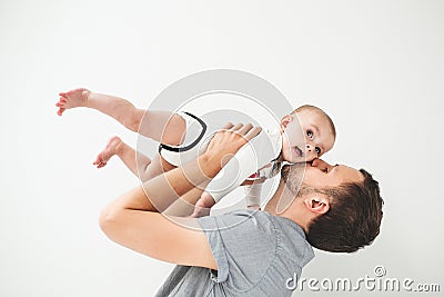 Happy father holding baby in hands over head isolated background Stock Photo