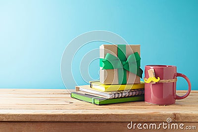 Happy Father's day concept with colorful coffee cup, mustache, notebook and gift box on wooden table over blue background Stock Photo