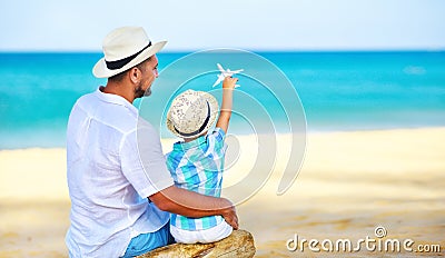 Happy father`s day! dad and child son on beach by sea with model toy plane Stock Photo