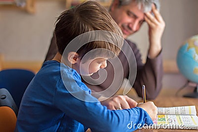 Happy father and son cooperating on mathematics homework Stock Photo