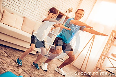 Happy Father and Son Doing Squats in Apartment. Stock Photo