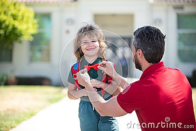 Happy father and son go to elementary school. Parent taking child to primary school. Positive human emotion. Stock Photo