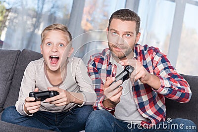 Father and son playing with joysticks Stock Photo