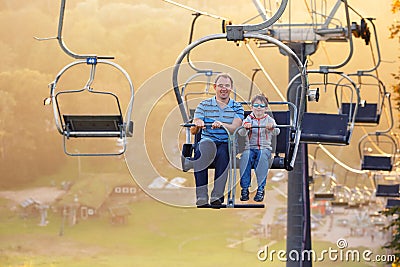 Happy father and son ride chair lift Stock Photo