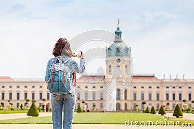 Female asian tourist in the baroque garden in front of the ancient architecture of royal Charlottenburg palace. Sightseeing Stock Photo