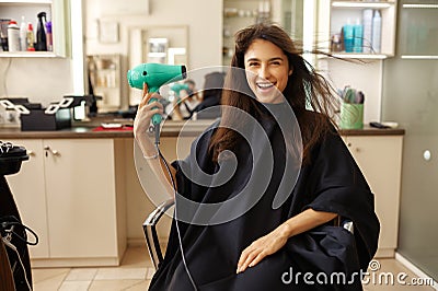 Happy female customer using hairdryer, hairsalon Stock Photo