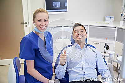 Happy female dentist with man patient at clinic Stock Photo