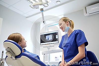 Happy female dentist with patient girl at clinic Stock Photo