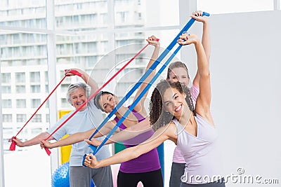 Happy female friends exercising with resistance bands Stock Photo