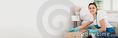 Female Housekeeper Cleaning Nightstand Stock Photo