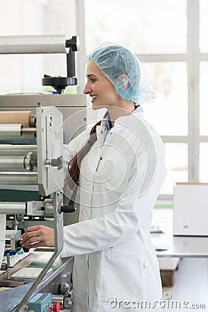 Happy manufacturing operator working with modern equipment in fa Stock Photo