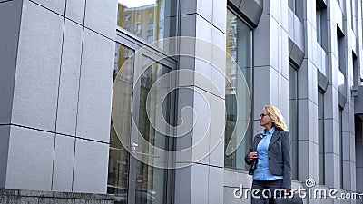 Happy female politician admiring reflection in office building glass, career Stock Photo