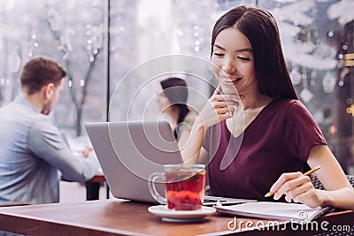 Happy female student using laptop for studying Stock Photo