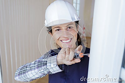 happy female worker screwing window Stock Photo