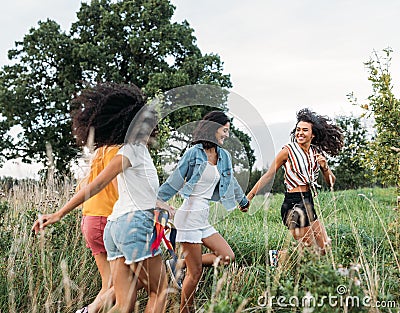 Happy females running on field enjoying summer journey Stock Photo