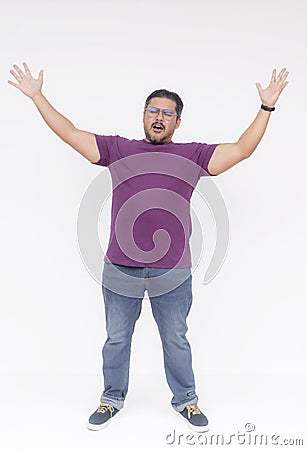 Happy fervent man with glasses raising his arms in victory against a white background, expressing joy and success Stock Photo