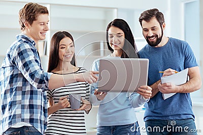 Happy four colleagues checking documents Stock Photo