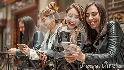 Happy four friends watching internet social media in cell phone Stock Photo