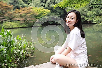 A happy free smile peace balance meditation beauty girl Asian Chinese travel hiking smell maple do yoga by lake bag hangzhou xihu Stock Photo