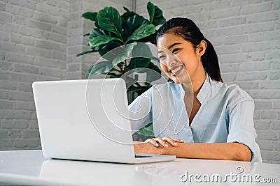 Happy friendly Asian woman using a laptop and talking, making video call conference, online job interview at home Stock Photo