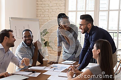 Happy friendly multiracial team laughing working together at corporate briefing Stock Photo