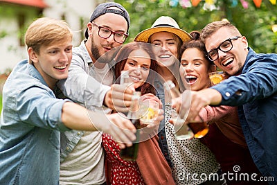 Happy friends clinking glasses at summer garden Stock Photo