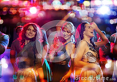 Happy friends dancing in club with holidays lights Stock Photo