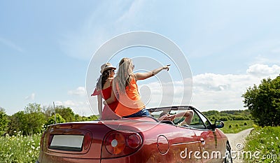 Happy friends driving in cabriolet car at country Stock Photo