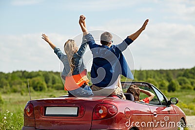 Happy friends driving in cabriolet car at country Stock Photo