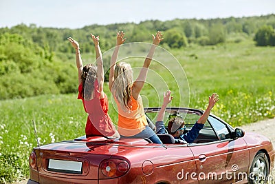Happy friends driving in cabriolet car at country Stock Photo