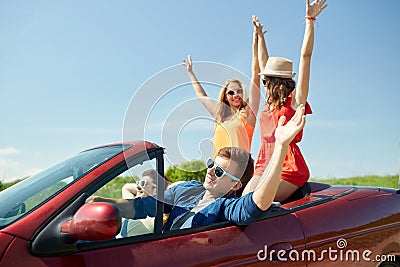 Happy friends driving in cabriolet car at country Stock Photo