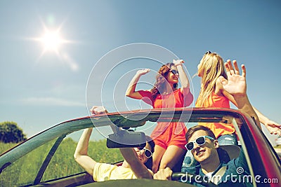 Happy friends driving in cabriolet car Stock Photo