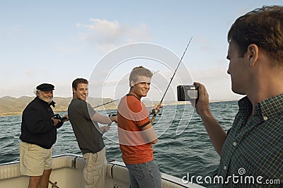 Happy Friends Fishing On Yacht Stock Photo