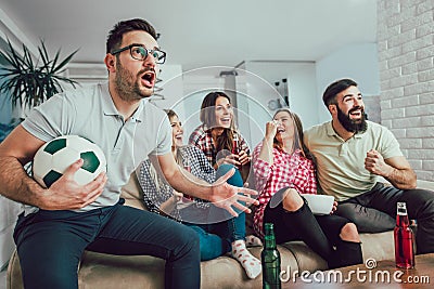 Happy friends or football fans watching soccer on tv Stock Photo