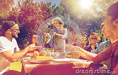 Happy friends having dinner at summer garden party Stock Photo
