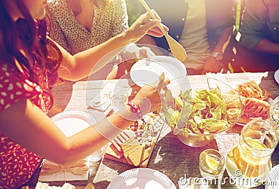 Happy friends having dinner at summer party Stock Photo