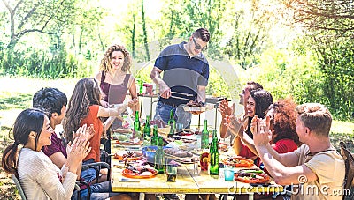 Happy friends having fun together at barbecue picnic party - Young people millenials at pic nic on open air festival Stock Photo