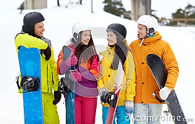 Happy friends in helmets with snowboards talking Stock Photo