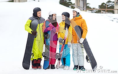Happy friends in helmets with snowboards talking Stock Photo
