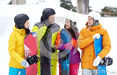 Happy friends in helmets with snowboards talking Stock Photo