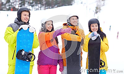 Happy friends in helmets with snowboards Stock Photo