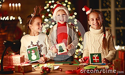 Happy friends kids draw decorations and write letter to Santa near Christmas tree Stock Photo