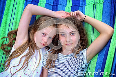 Friends are laughing on a hammock on a hot sunny day Stock Photo